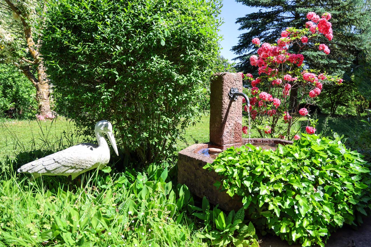 Seniorenresidenz Landhaus am Weinberg Brunnen mit Blumen im Garten
